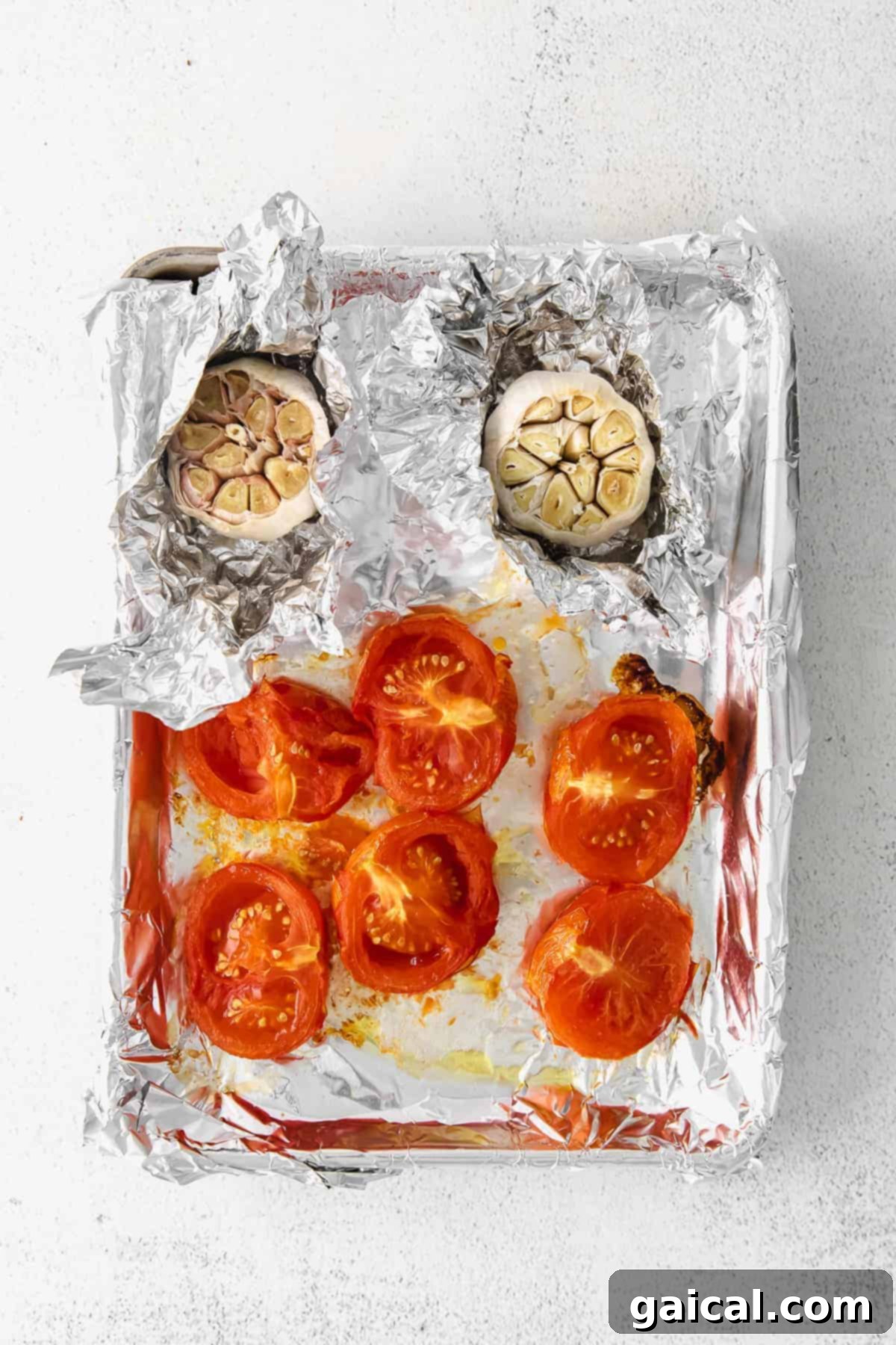 Roasted Tomatoes and Garlic for Pasta Sauce Sheet pan with perfectly roasted tomatoes and whole heads of garlic, caramelized and ready for the pasta sauce