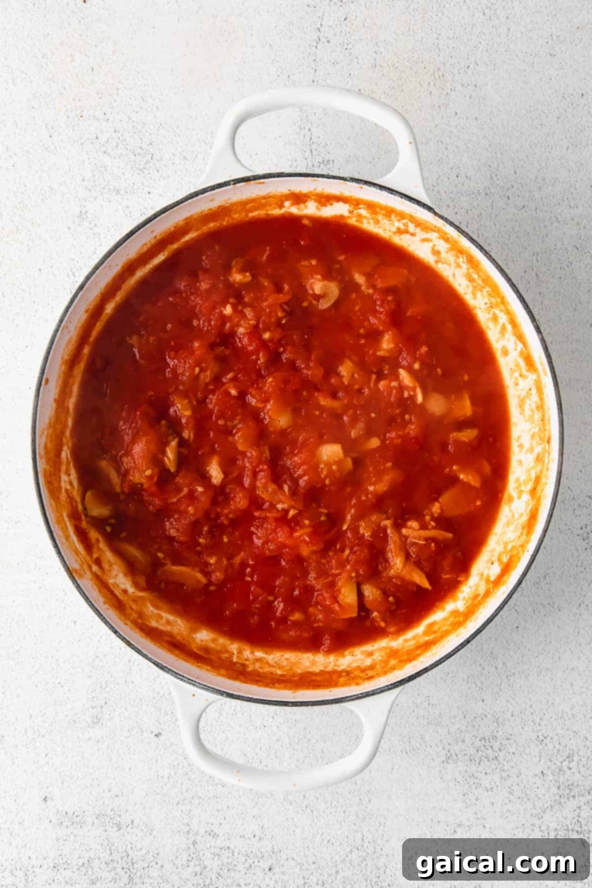 Simmering Pasta Sauce in Dutch Oven Delicious creamy pasta sauce simmering in a Dutch oven, rich with roasted tomatoes and garlic