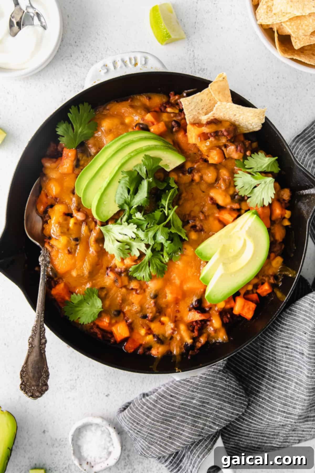 This turkey sweet potato enchilada skillet is a true one pot meal that comes together in 30 minutes flat. Enjoy this easy weeknight dinner tonight! turkey sweet potato enchilada skillet topped with fresh avocado and cilantro