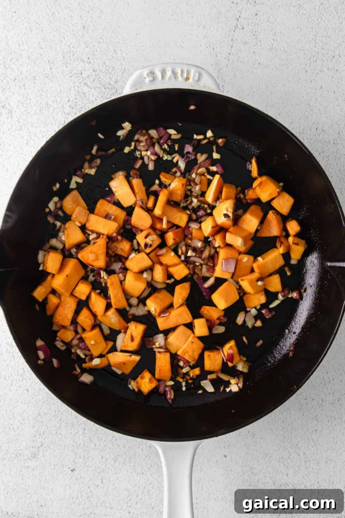 This turkey sweet potato enchilada skillet is a true one pot meal that comes together in 30 minutes flat. Enjoy this easy weeknight dinner tonight! diced sweet potatoes in a cast iron skillet