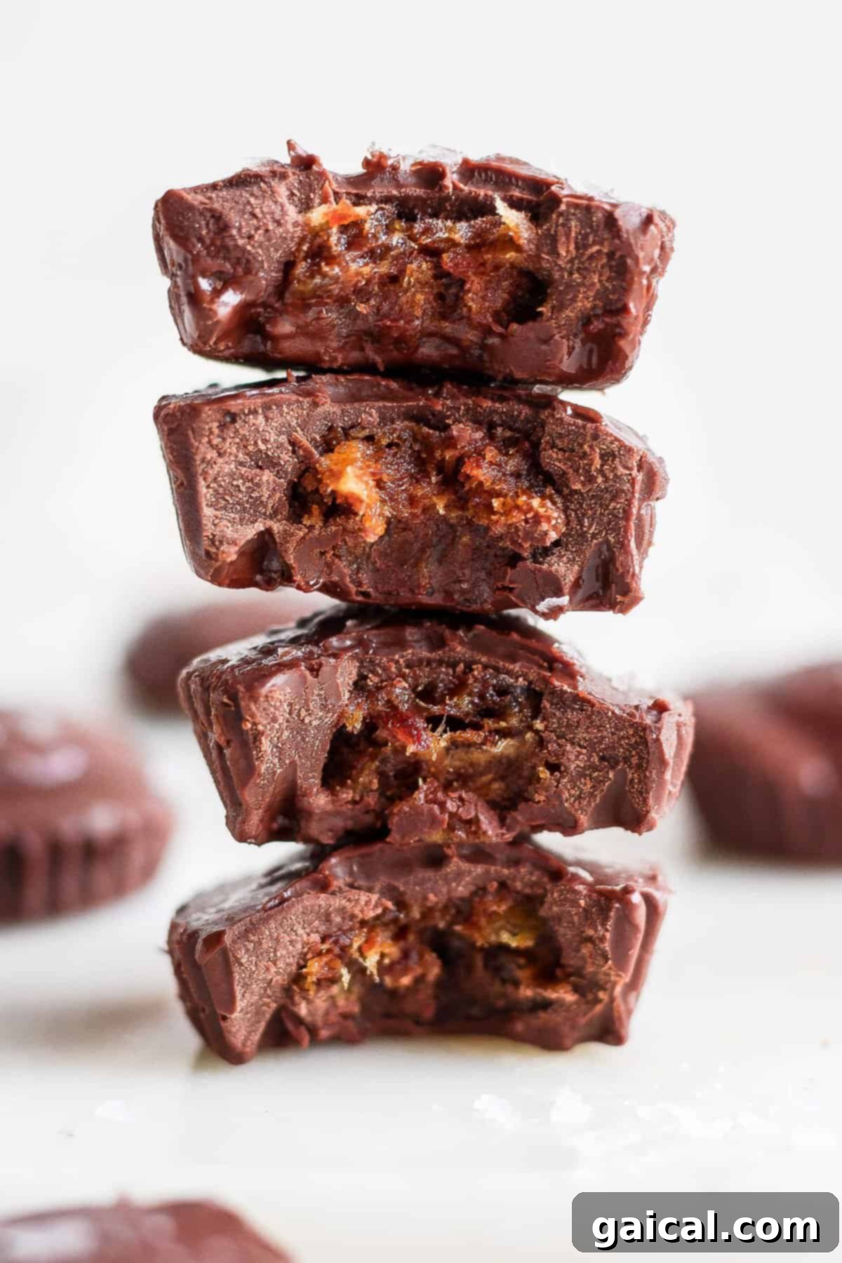 Salted Caramel Date Bites 2 A stack of rich chocolate pieces, one with a bite taken out, symbolizing the indulgent yet healthy nature of date cups.