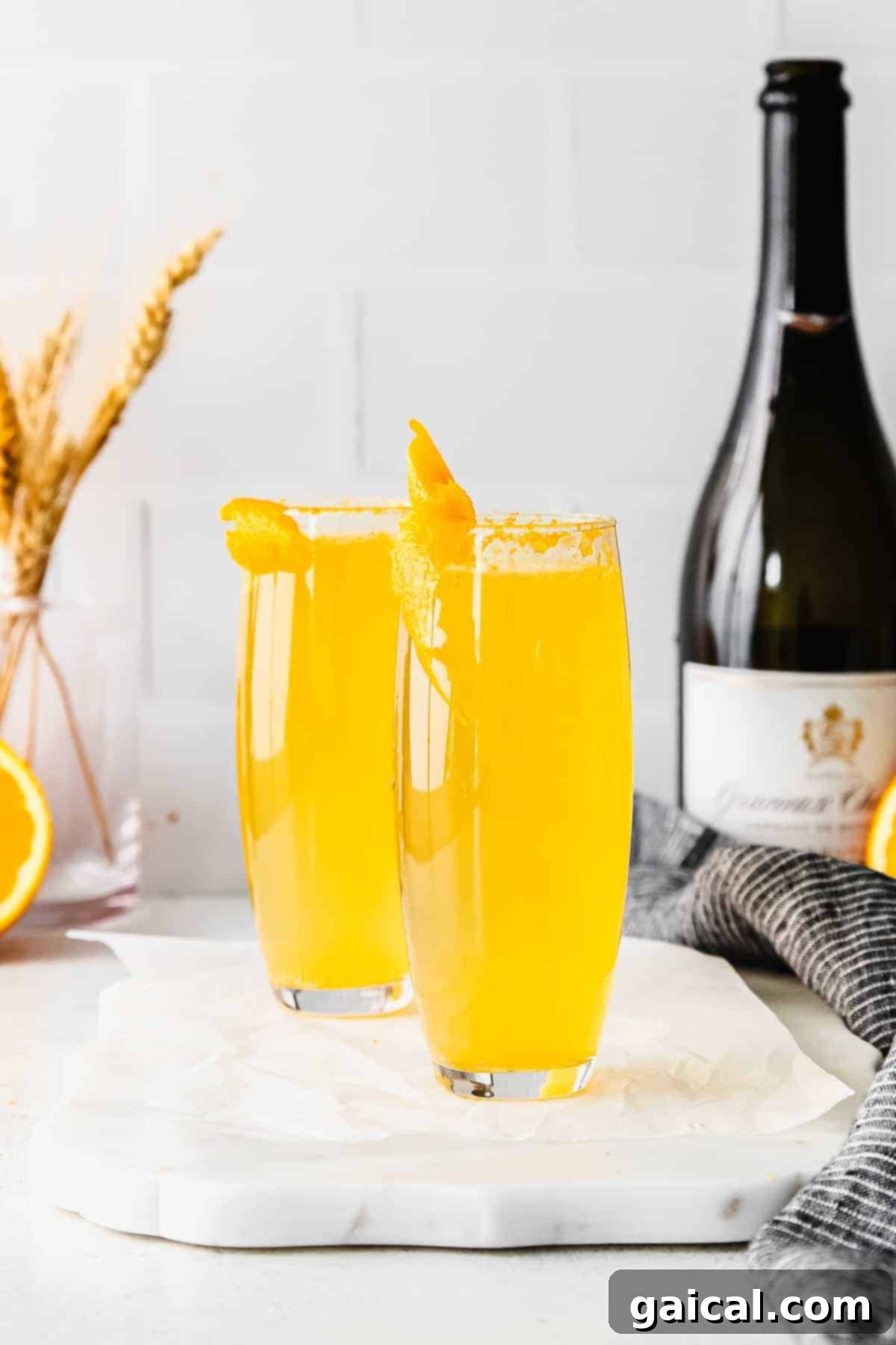 Classic Mimosa in Stemless Flutes Two perfectly poured mimosas in elegant stemless champagne flutes, ready to be enjoyed at brunch.