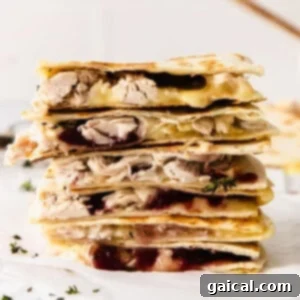 A stack of leftover Thanksgiving turkey quesadillas with cranberry sauce.