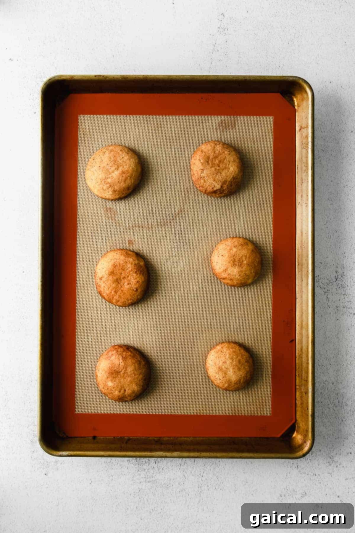 Quick Snickerdoodle Delight 6 Freshly baked snickerdoodles arranged on a baking sheet, golden and inviting.