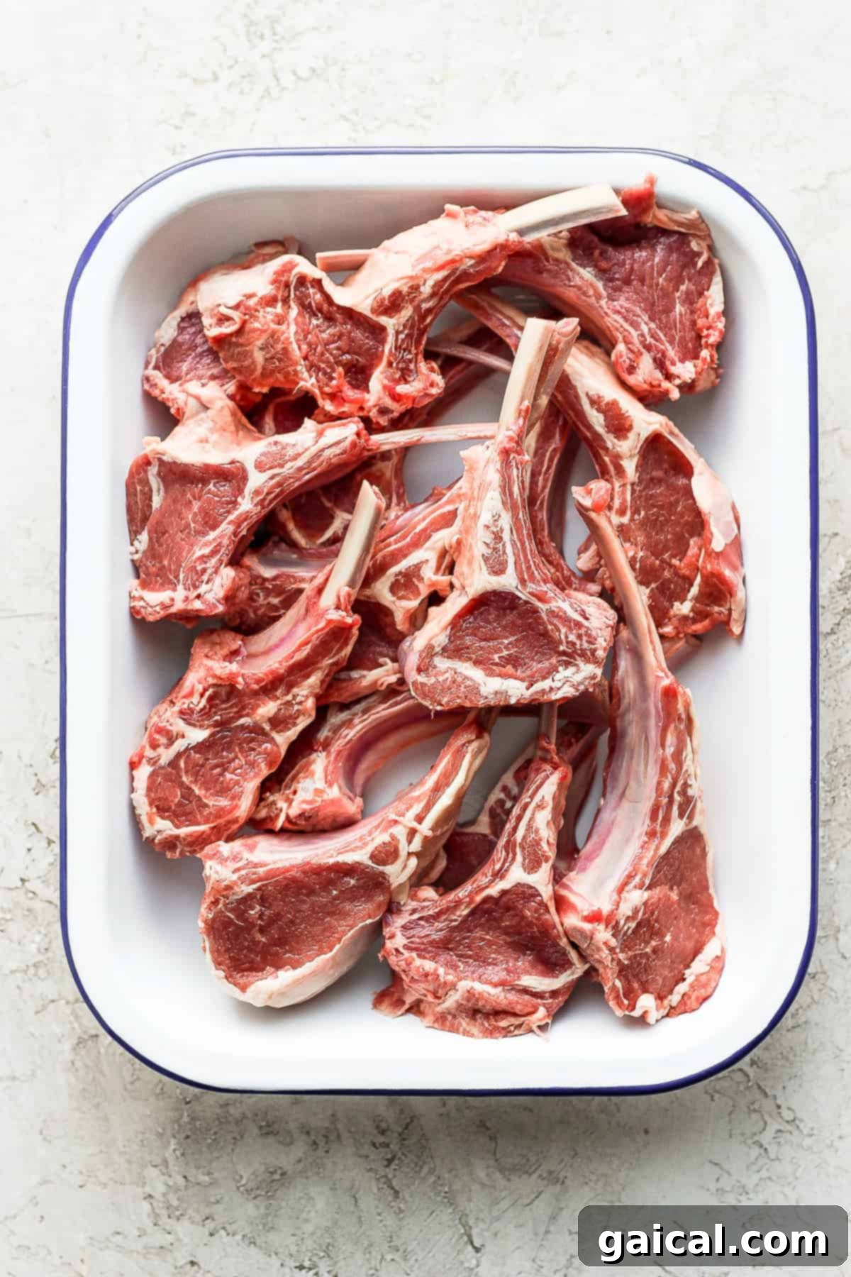 Preparing Raw Lamb Chops for Seasoning Raw lamb chops expertly cut and ready for seasoning in a baking dish.