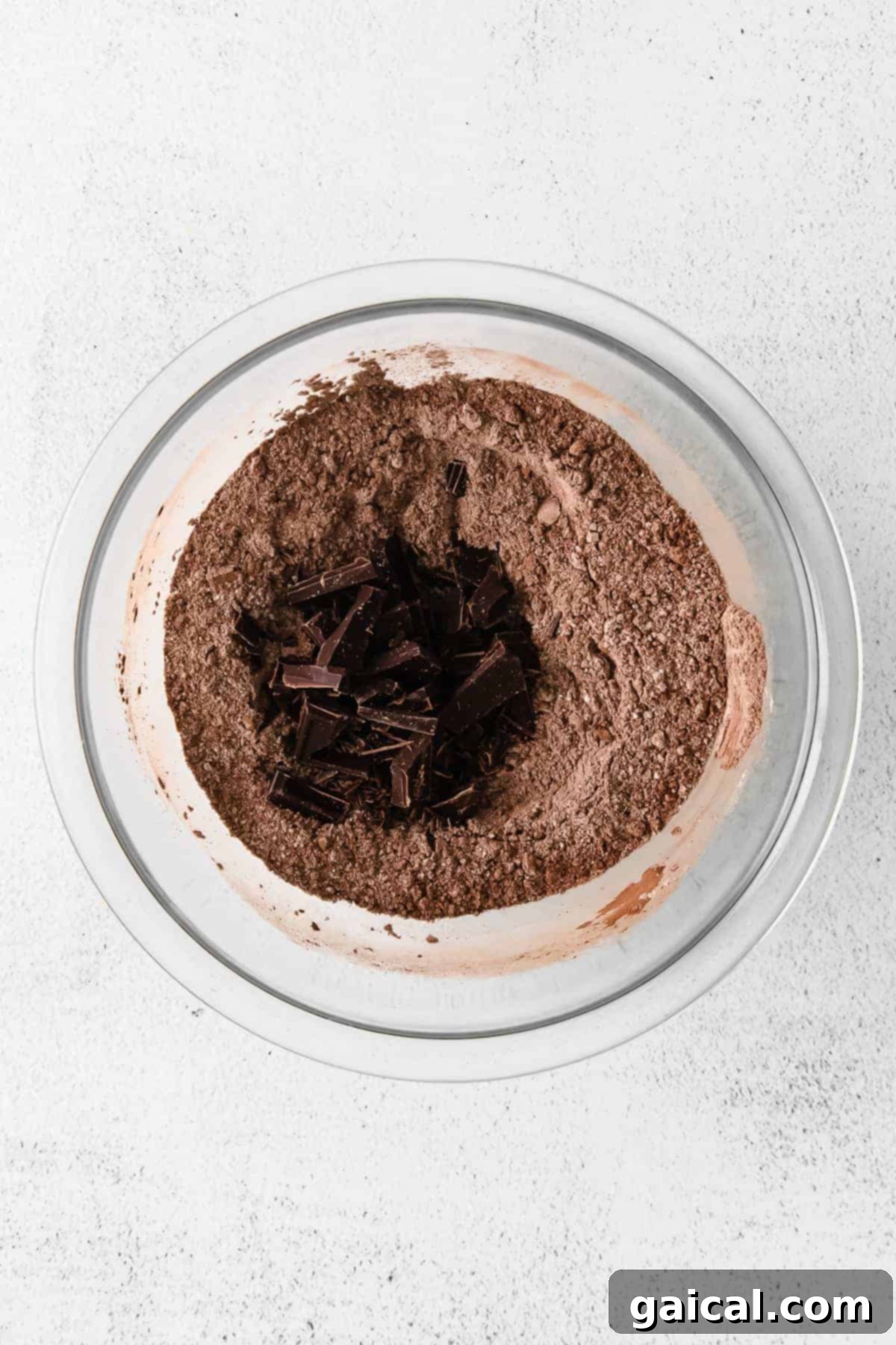 Mixing the Dry Ingredients for Rich Chocolate Flavor Dry ingredients for crinkle cookies, including flour and cocoa powder, mixed in a large glass bowl.