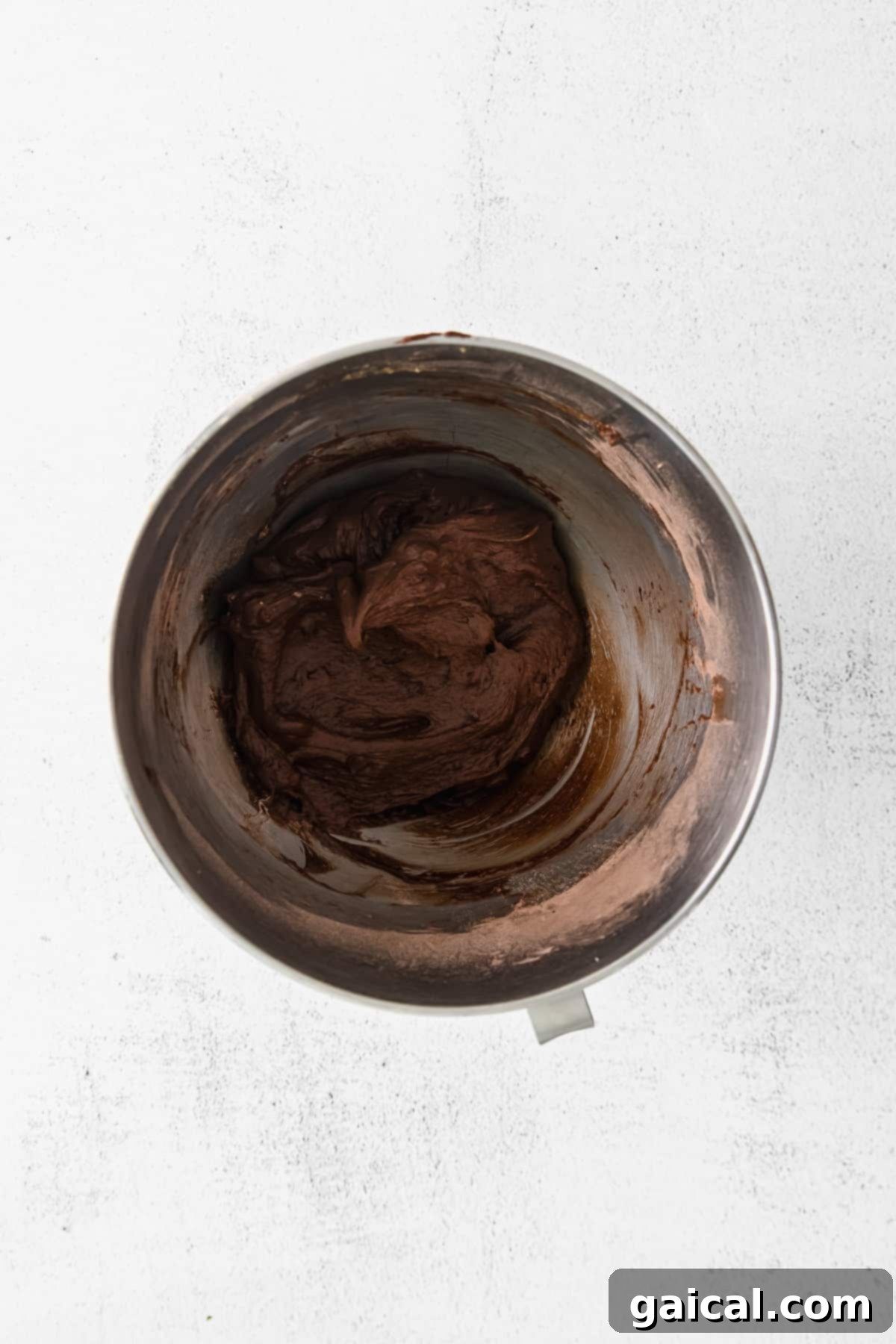 The Heart of the Cookie: Perfectly Mixed Dough Rich chocolate cookie dough mixing in a stand mixer, showcasing its glossy and smooth texture.