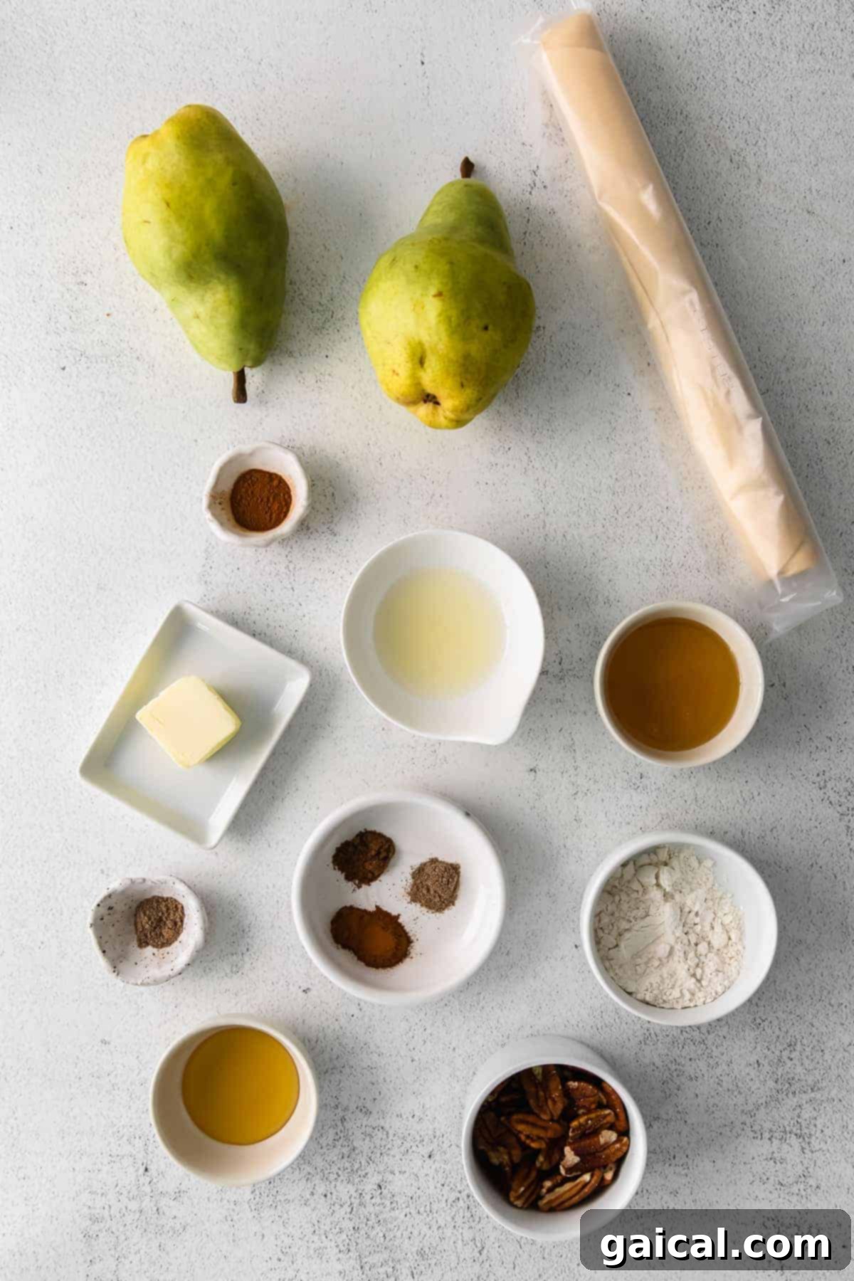 Ingredients laid out for making a honey pear galette, including pears, spices, pecans, and a pie crust.