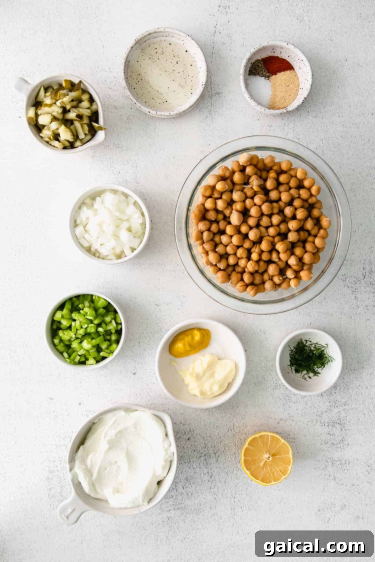 Assortment of fresh ingredients laid out on a kitchen counter for making chickpea salad.
