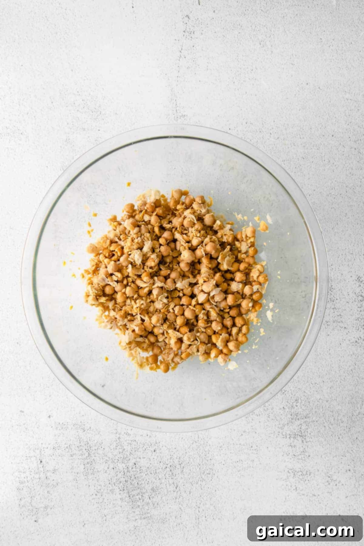 Close-up of mashed garbanzo beans in a bowl, ready for the other ingredients to be added.