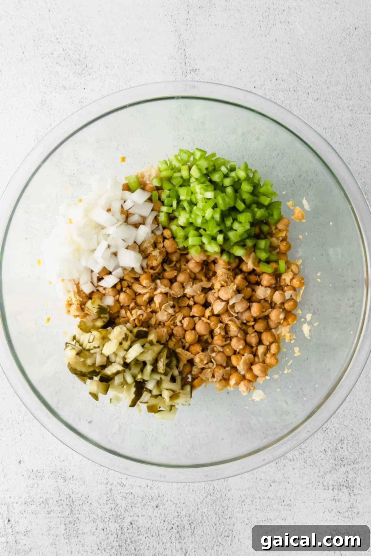 Bowl filled with all the ingredients for chickpea salad before mixing the dressing in.