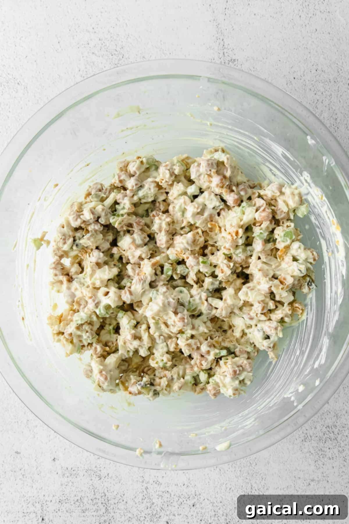 A bowl of freshly made chickpea salad, garnished with fresh dill and paprika.