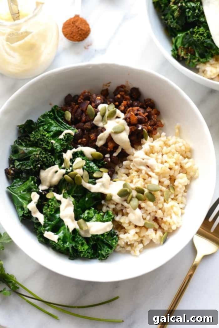 A perfectly assembled savory breakfast bowl, showcasing the rich colors and textures of the black beans, egg, kale, and pumpkin seeds.