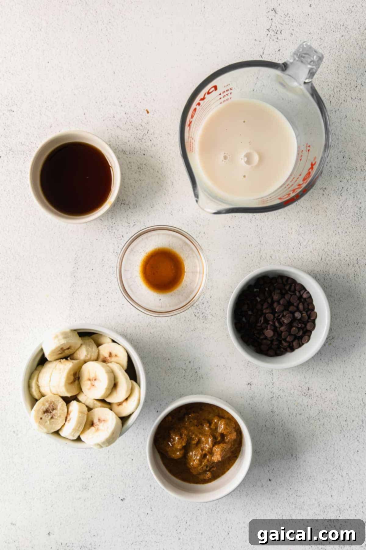 A vibrant flat lay showing all the fresh and wholesome ingredients meticulously arranged in small bowls, ready to be blended into a delicious cookie dough smoothie.