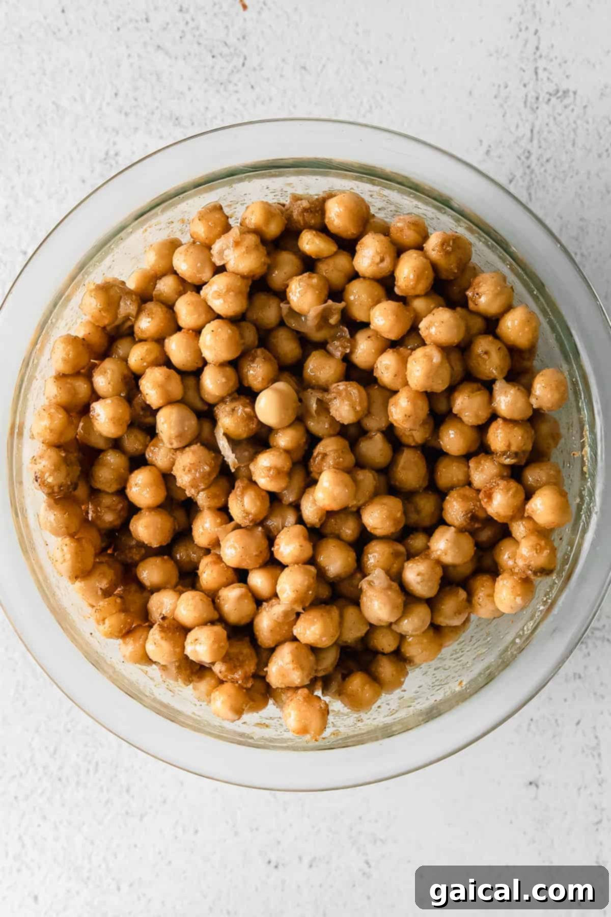 Tek Tencere Marine Nohutlu Sarı Pilav 5 Chickpeas marinating in a bowl with melted ghee and spices.