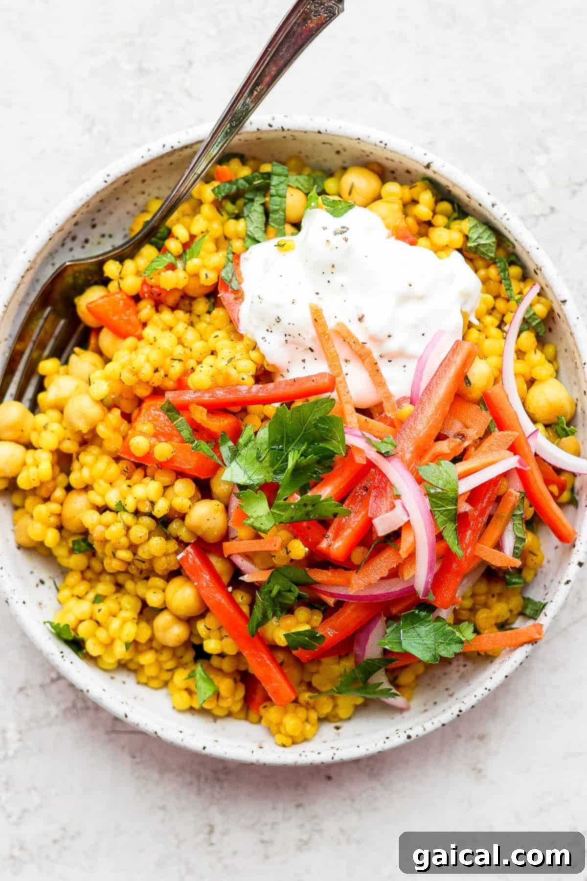 Zesty Lemon Garlic Israeli Couscous with Creamy Feta 2 Lemon Garlic Israeli Couscous topped with creamy whipped feta, fresh herbs, and colorful pickled vegetables, showcasing a healthy and vibrant meal.