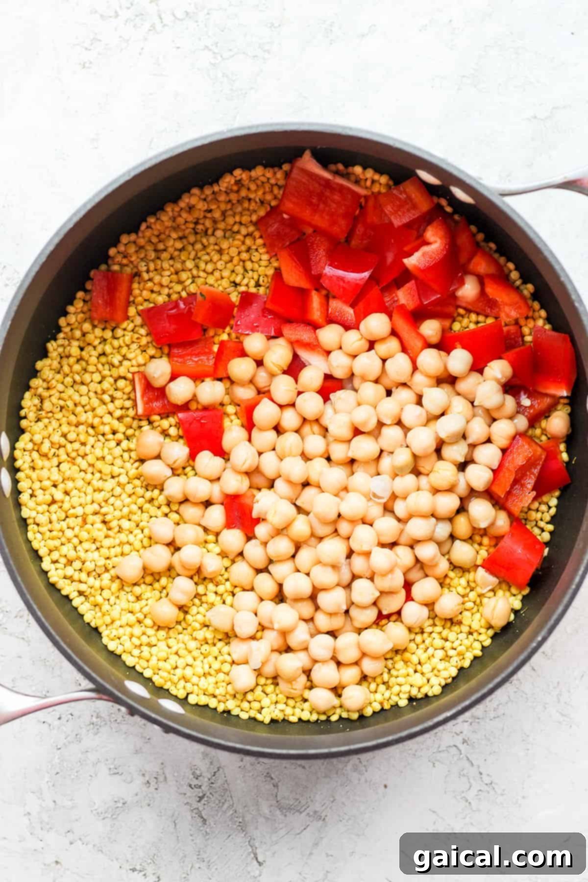 Zesty Lemon Garlic Israeli Couscous with Creamy Feta 4 Red bell peppers, wholesome chickpeas, and pearl couscous simmering together in a pot, absorbing aromatic broth and spices.