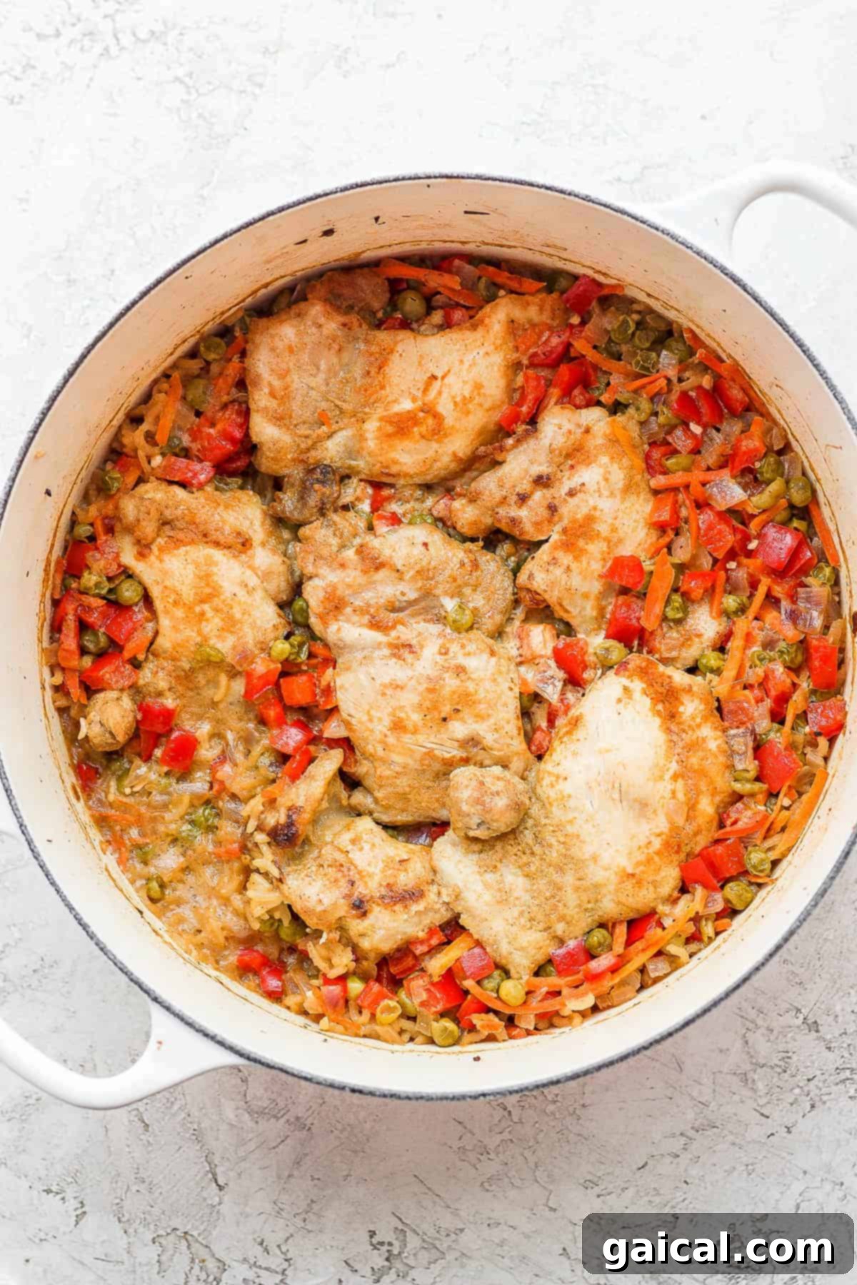 Cooked Chicken and Rice in Dutch Oven The finished one-pot green curry chicken and rice, perfectly cooked and bubbling gently in the Dutch oven.