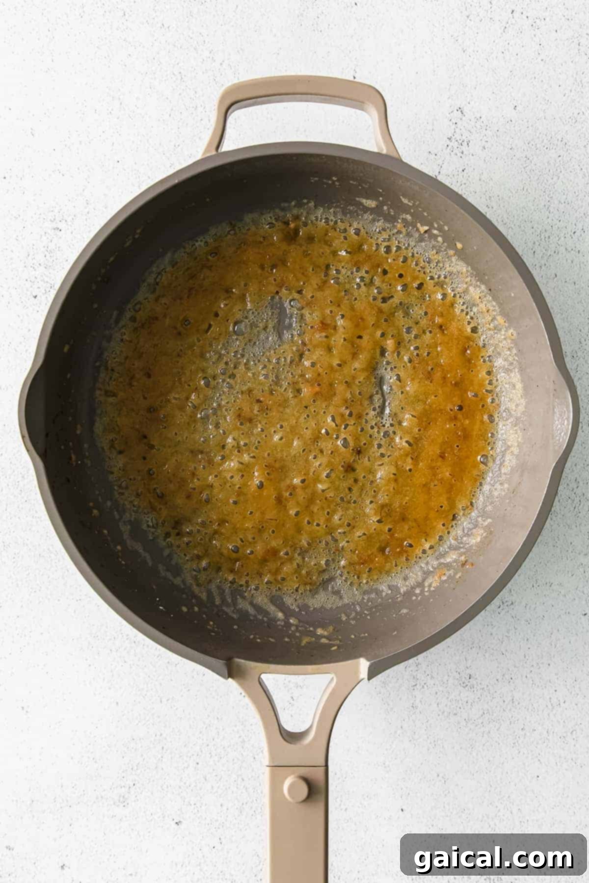 Melted butter and flour creating a roux in a skillet, the base for a rich alfredo sauce.