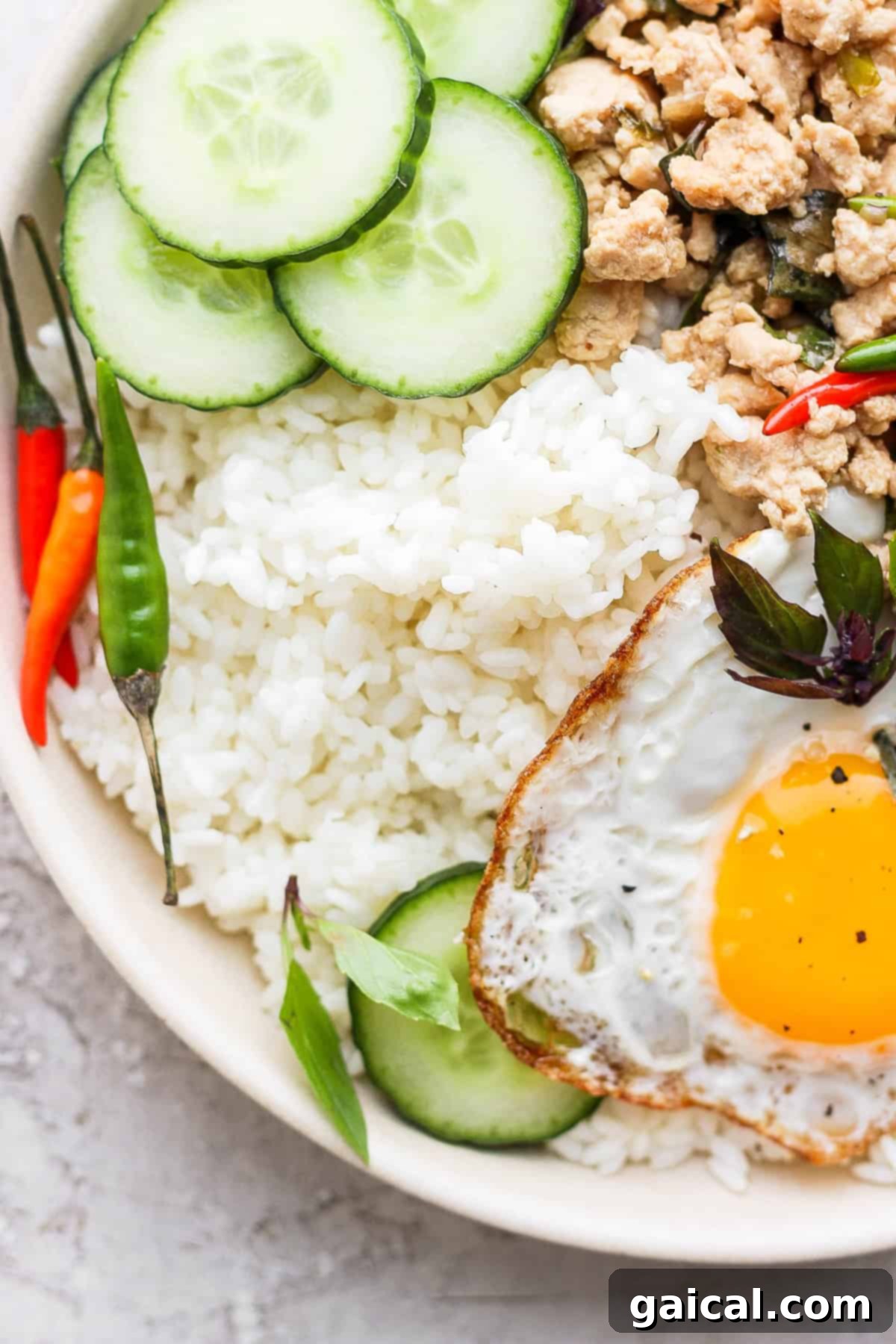 A hearty bowl featuring sticky rice served alongside vibrant Pad Krapow (Thai Basil Stir Fry), showcasing a delicious meal combination.