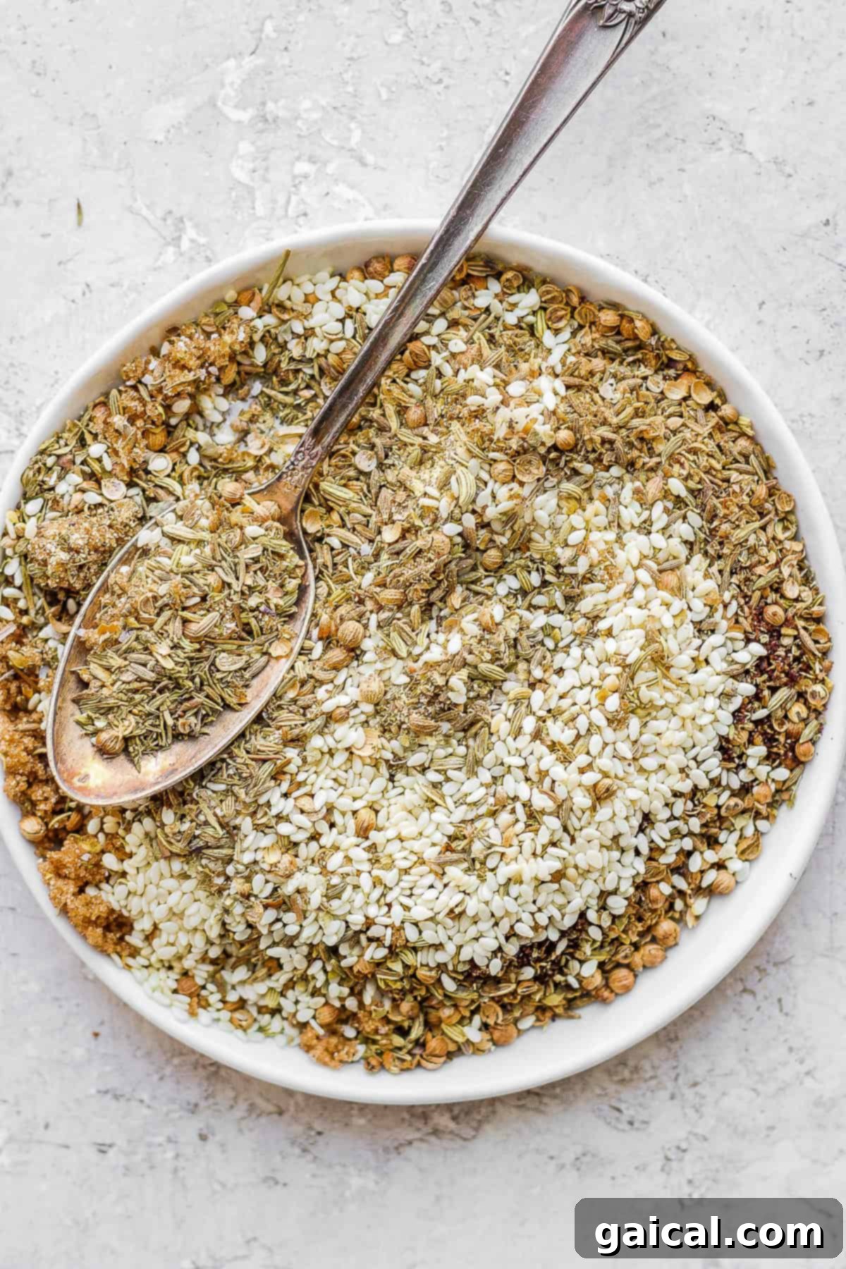 Homemade Za'atar Seasoning: A Perfect Blend of Savory, Sweet, and Umami Freshly made za'atar seasoning on a plate with a spoon, ready for use.