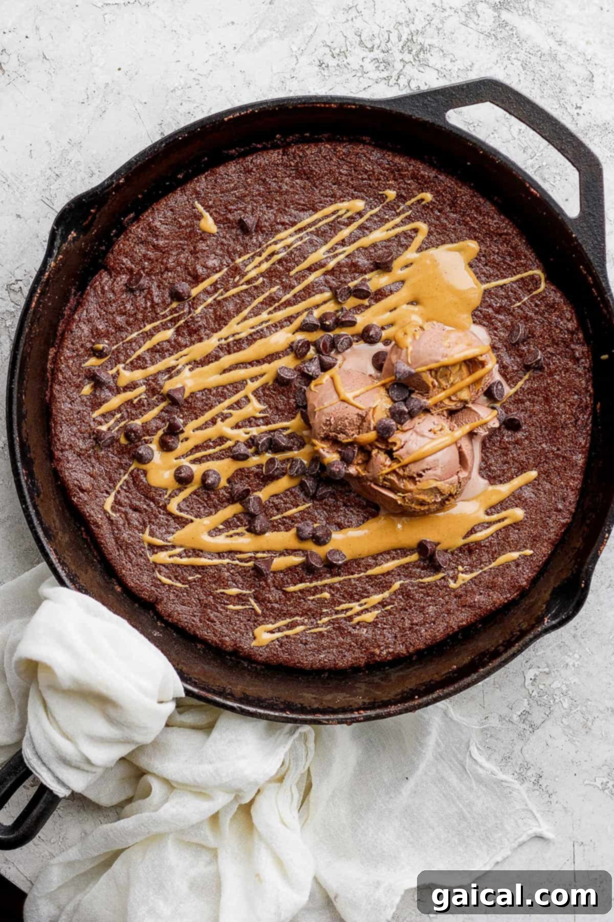 6-Ingredient Flourless Chocolate Skillet Cake with Ice Cream Flourless chocolate skillet cake topped with vanilla ice cream and mini chocolate chips, ready to be served.