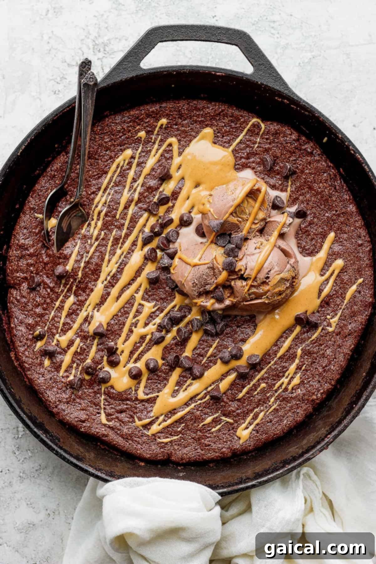 Decadent Skillet Cake with Ice Cream A close-up of the flourless chocolate skillet cake, beautifully topped with melting ice cream and mini chocolate chips, ready to be served.
