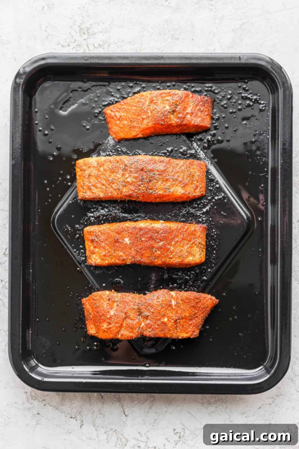 Salmon fillets placed skin-side down in an air fryer basket, ready for cooking to achieve crispy perfection.