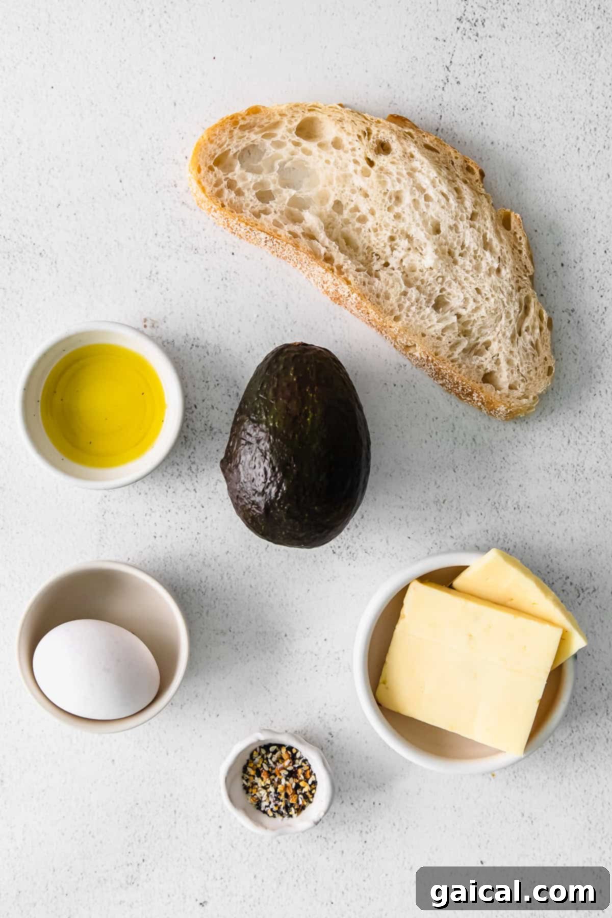 Assorted ingredients for avocado toast, including fresh avocados, bread, eggs, tomatoes, and herbs