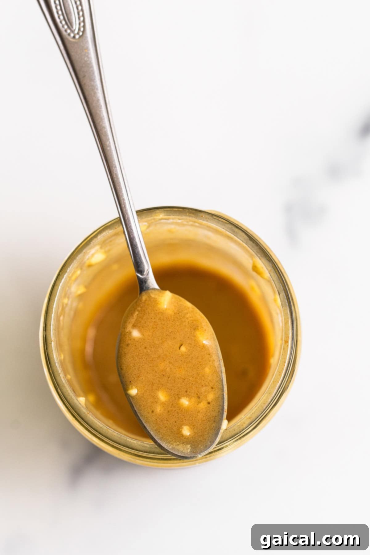 Homemade honey mustard dressing in a sealed mason jar, ready to be shaken and poured over the salad.