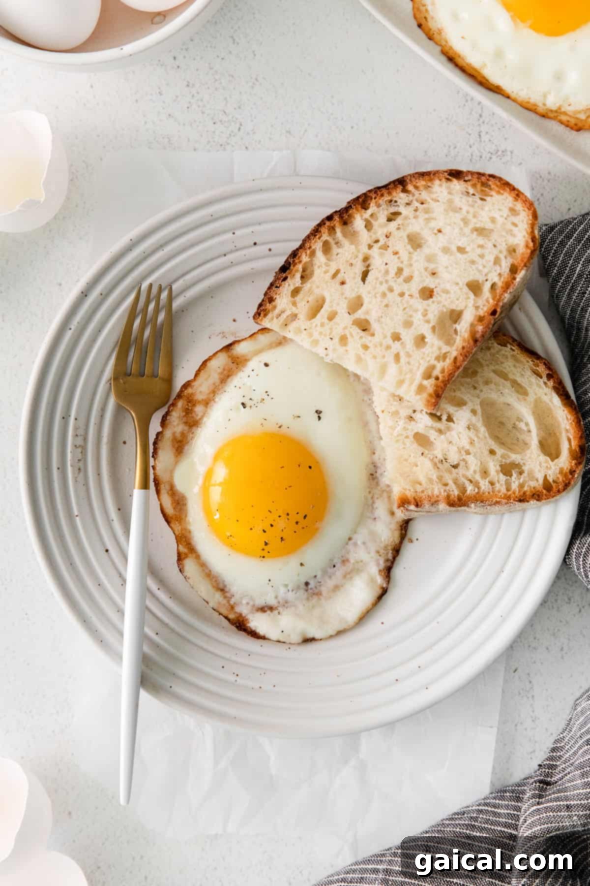Fry the Perfect Egg 7 A perfectly fried over-easy egg, with a glistening runny yolk, served on a plate.