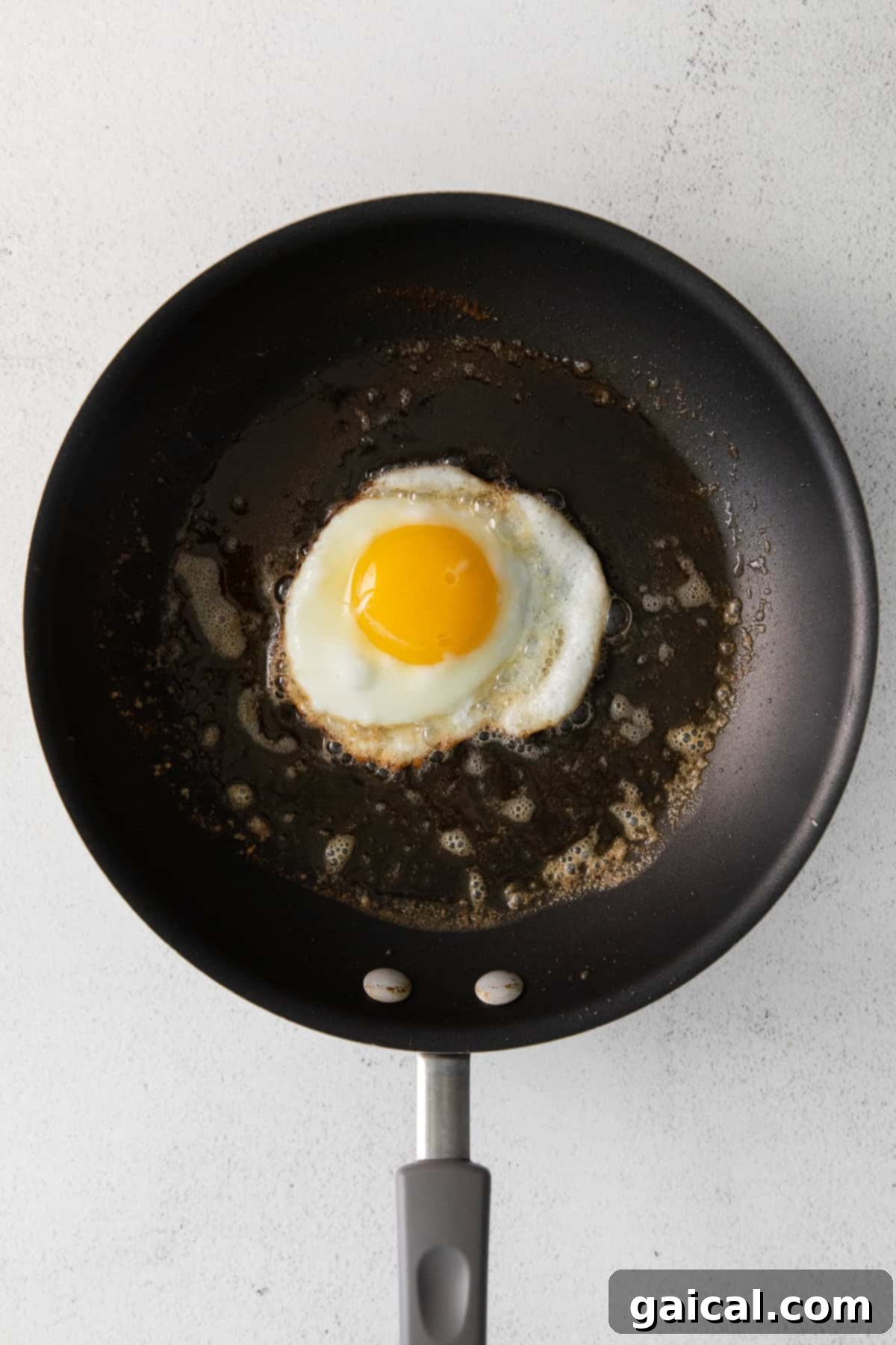 Fry the Perfect Egg 6 Frying an egg in melted butter in a nonstick pan, with the whites just starting to set.