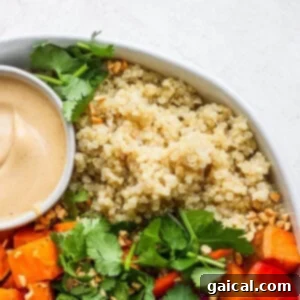 A vibrant coconut quinoa bowl with carrots and a dipping sauce, demonstrating a perfect serving suggestion.