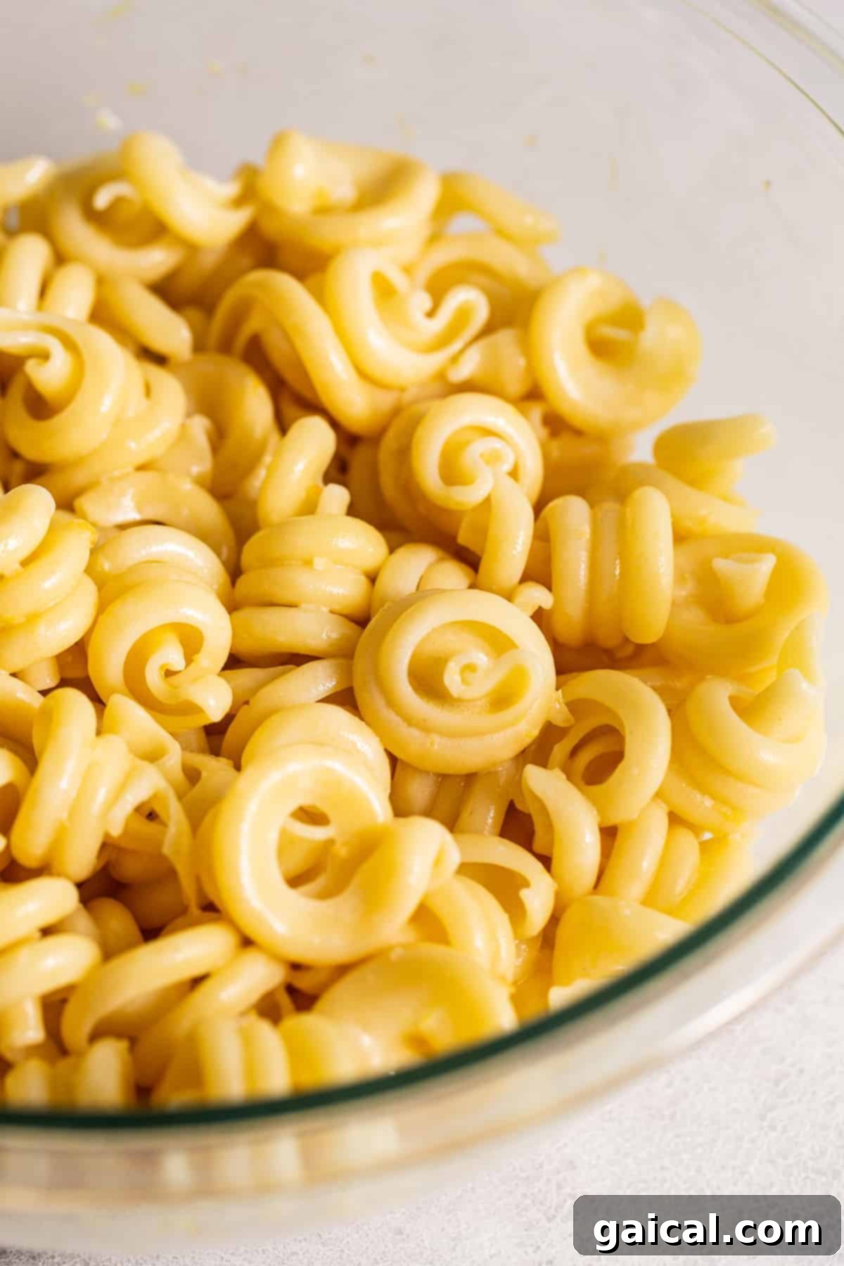 Al Dente Pasta for Lemon Herb Salad Base Perfectly cooked short pasta noodles in a large bowl, ready to be tossed with the flavorful dressing