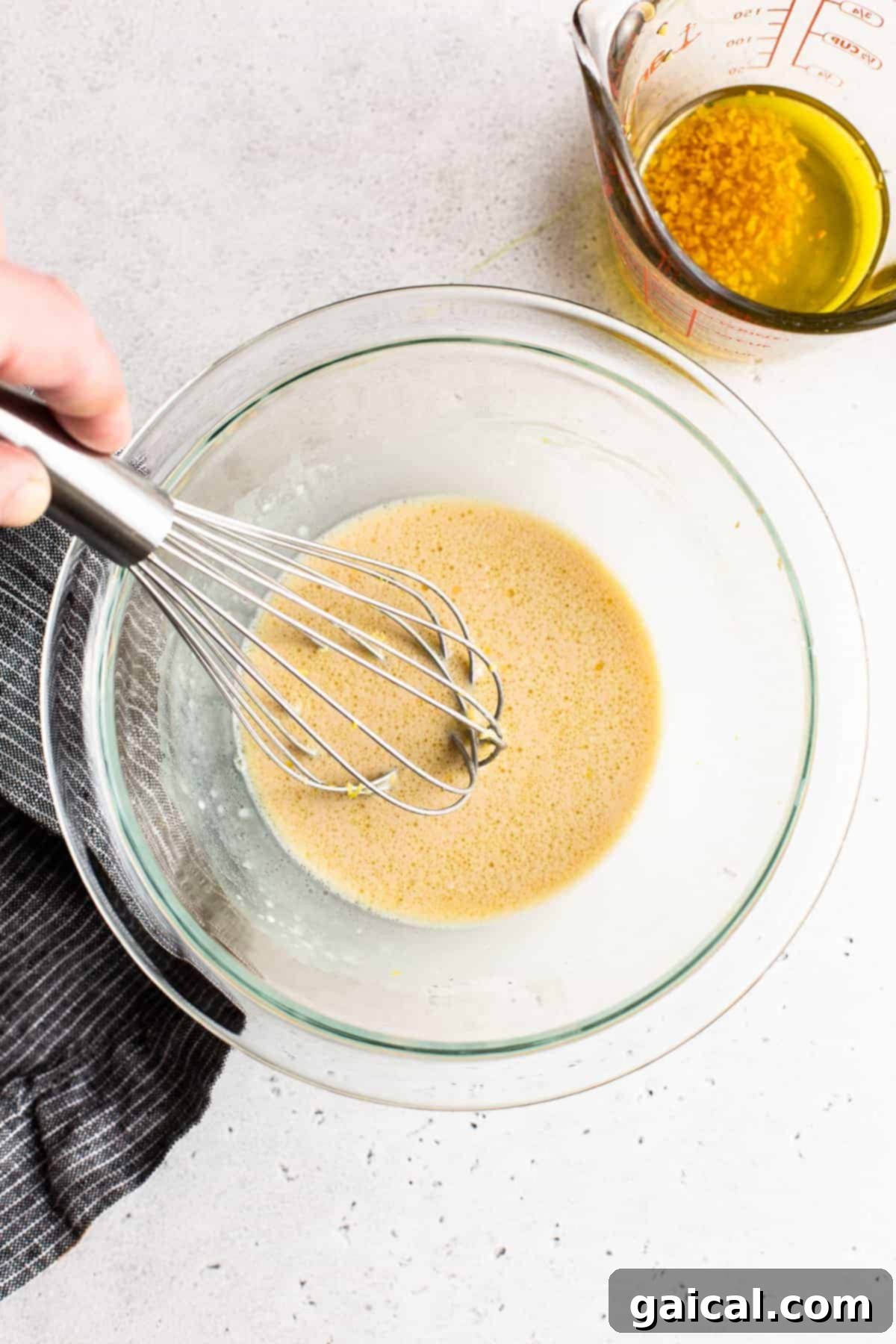 Homemade Lemon Garlic Dressing for Pasta Salad Close-up of the vibrant, creamy lemon garlic dressing in a clear glass bowl, showcasing its smooth texture