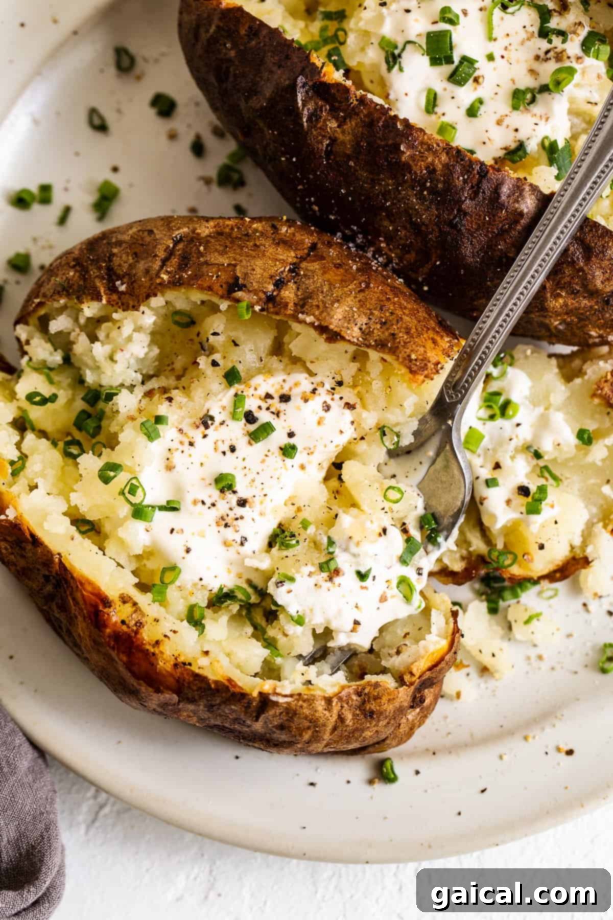 An array of perfectly baked potatoes arranged on a plate, ready to be served, showcasing their inviting texture.