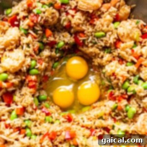 Scrambled eggs being mixed into a pan of fried rice