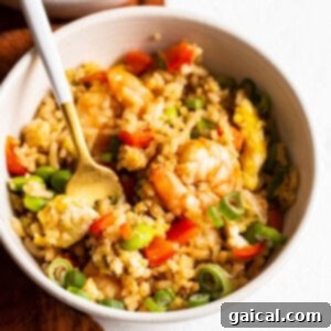 A small portion of shrimp fried rice in a square bowl, ready for serving