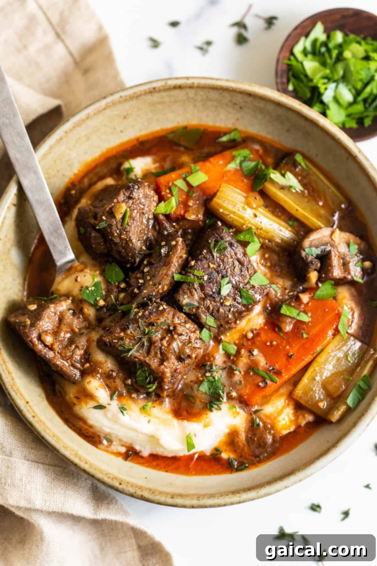 A bowl of Guinness beef stew served over creamy mashed potatoes, ready to be enjoyed.
