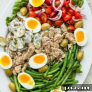 Close-up of a vibrant Nicoise Salad on a platter, emphasizing its rich colors and textures.