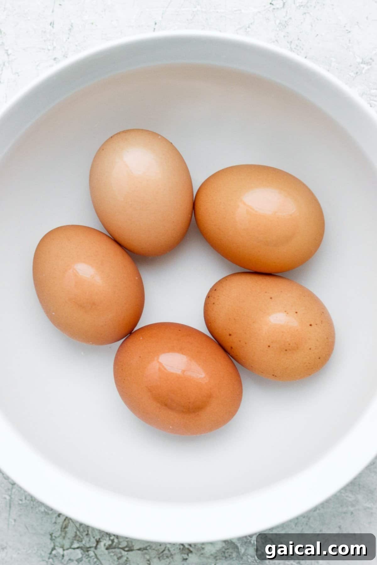 Fresh eggs gently cooking in a pot of simmering water, indicating preparation for medium-boiled eggs.