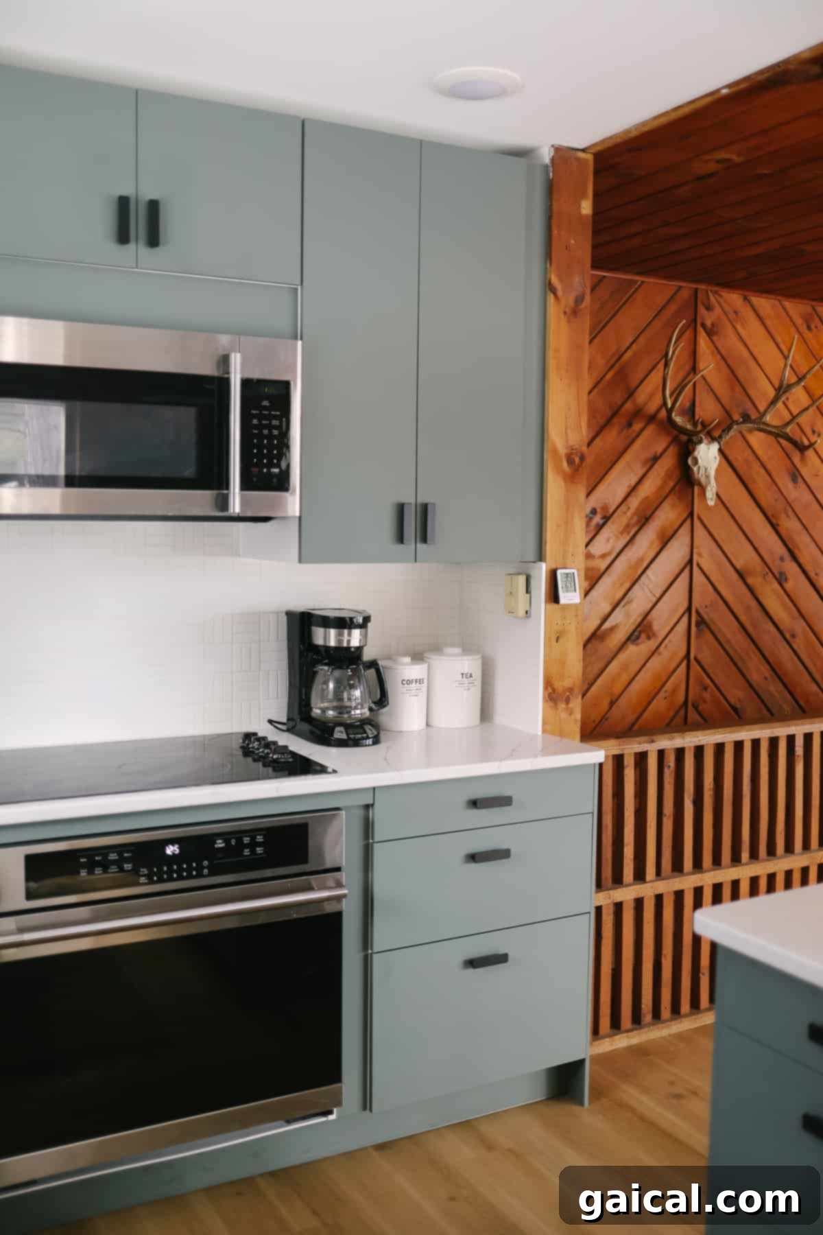 Green/grey IKEA kitchen cabinets with matte black pulls