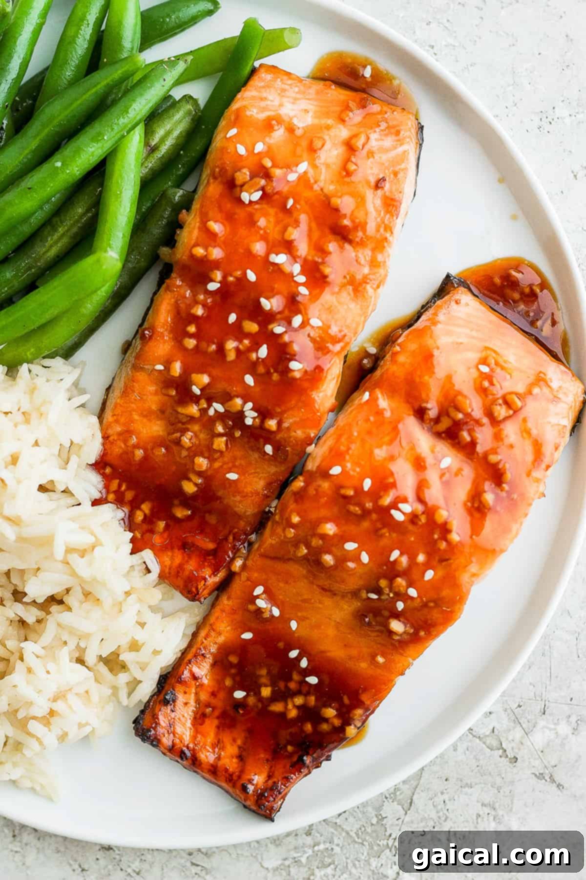 Delicious Teriyaki Salmon on a Plate Perfectly cooked teriyaki salmon served on a plate with rice and green onions.