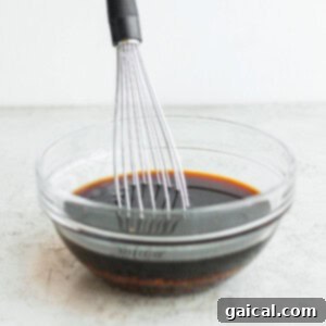 Sticky Teriyaki Salmon 6 A whisk in a bowl with a sauce, showing the blending of marinade ingredients.