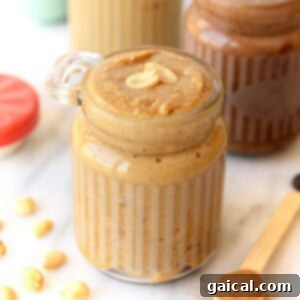 A jar of freshly made homemade peanut butter, ready to be served.
