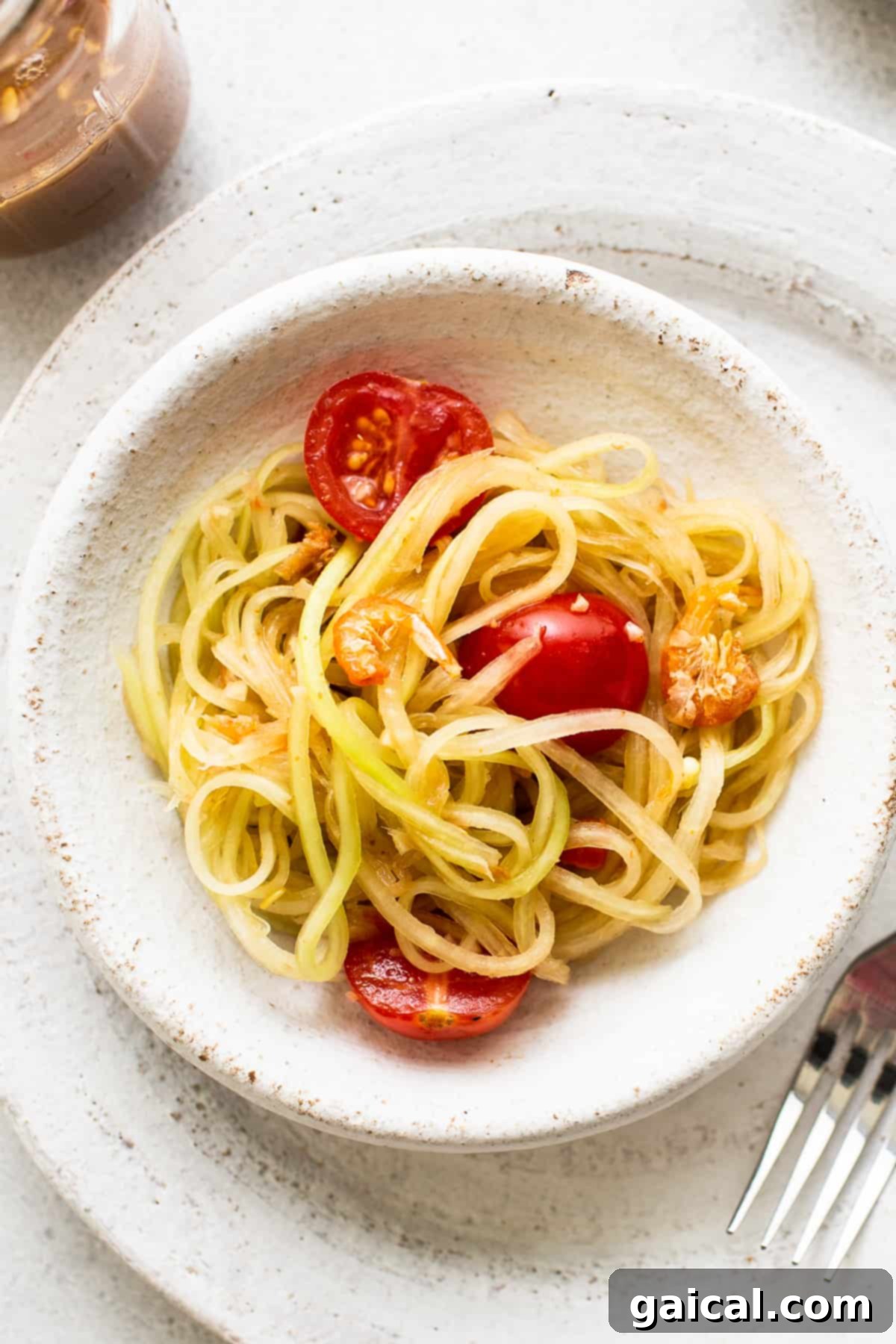 Authentic Green Papaya Salad: A Refreshing Thai and Lao Inspired Recipe A vibrant bowl of green papaya salad, showcasing shredded papaya, tomatoes, and herbs.