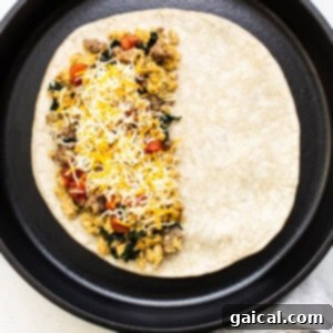 A green skillet filled with a breakfast burrito.