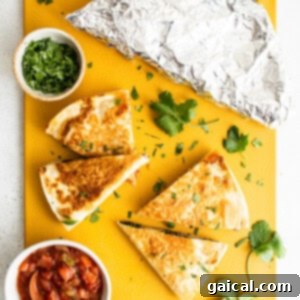 Quesadillas and guacamole on a yellow cutting board.