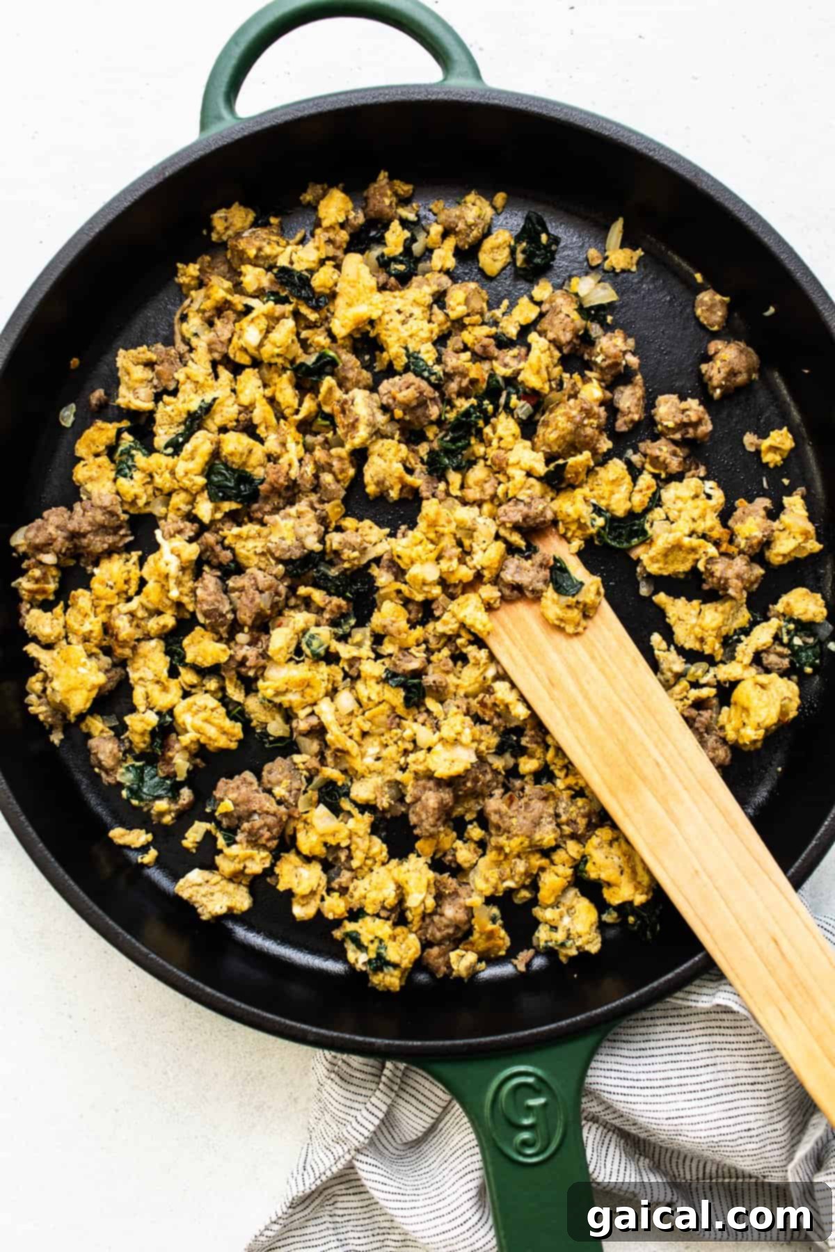 Key Ingredients for Flavorful Breakfast Quesadillas Scrambled eggs, breakfast sausage, and vibrant kale being sautéed in a trusty cast iron skillet.