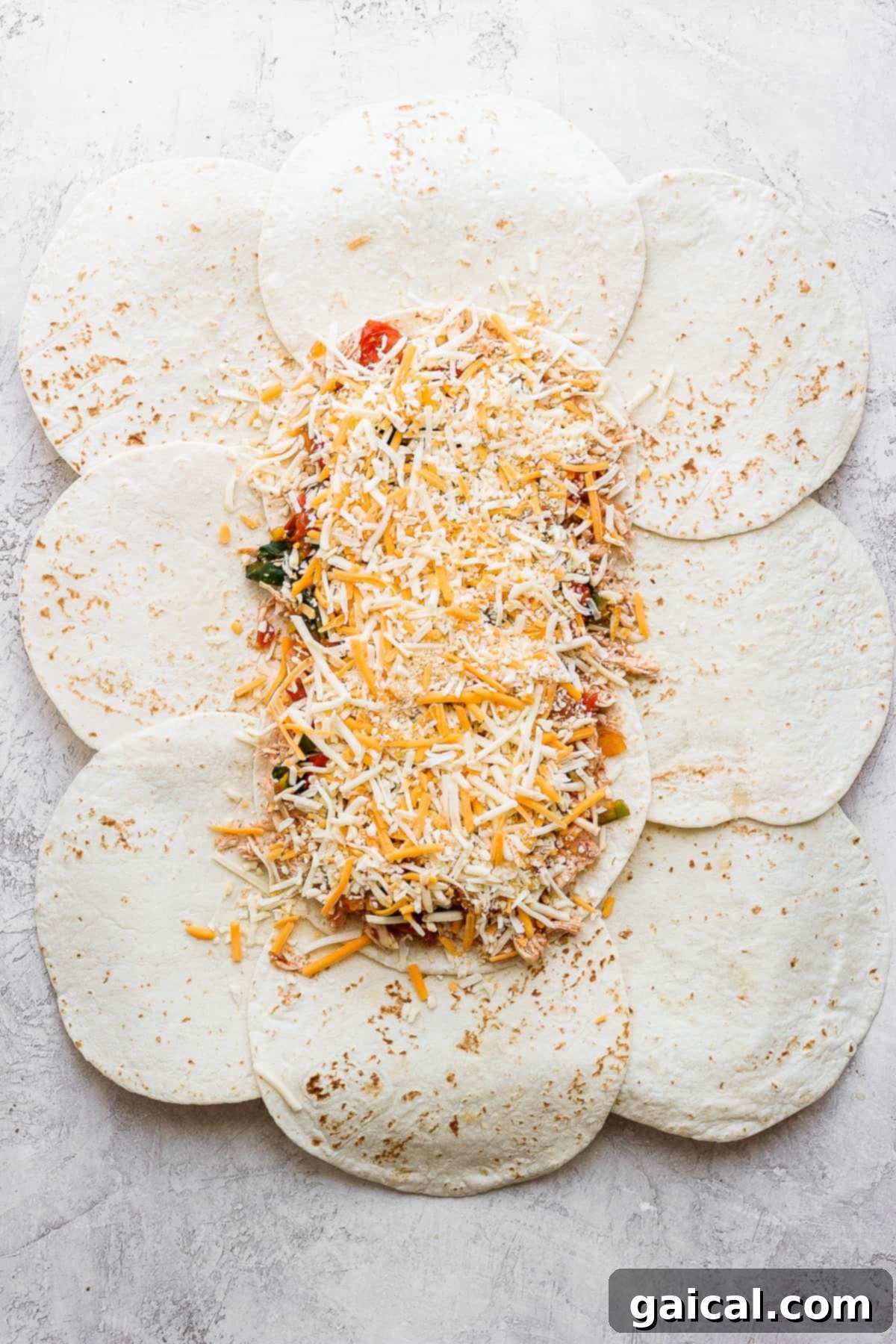Sheet Pan Quesadilla Party 4 Assembled sheet pan quesadilla with all the fillings spread on tortillas and edges folded in, ready for baking.